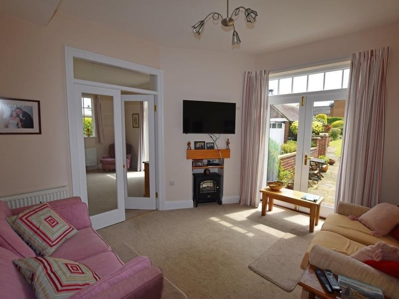 A sitting room, with patio doors leading outside.