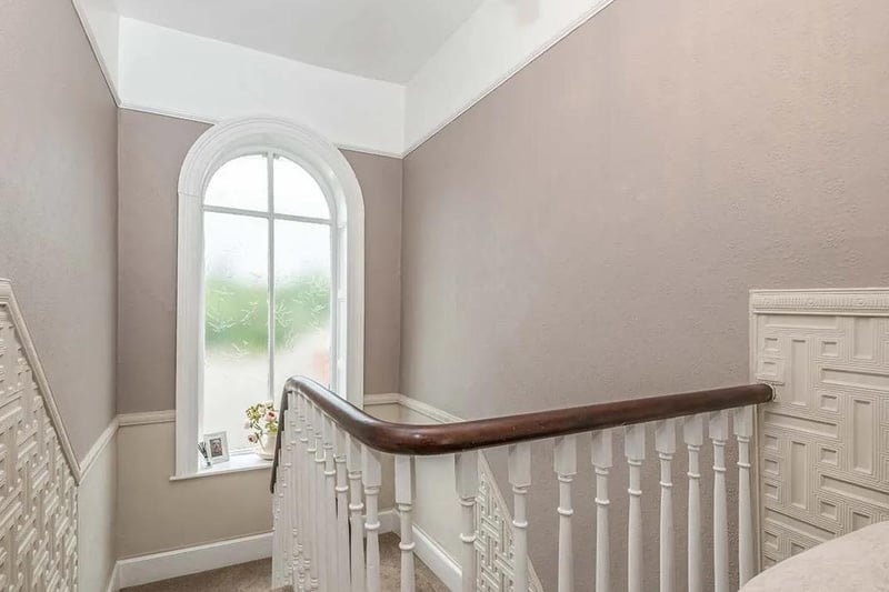 An arched window at a staircase landing