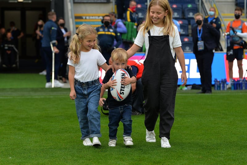 Their children - Macy, Maya and Jackson - bring out the match ball