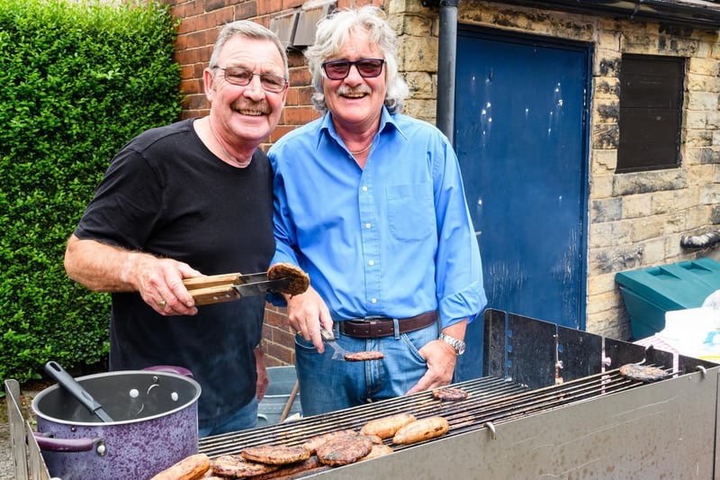 Terry Eyre and Geoff Bibby serve up burgers and hot dogs.
