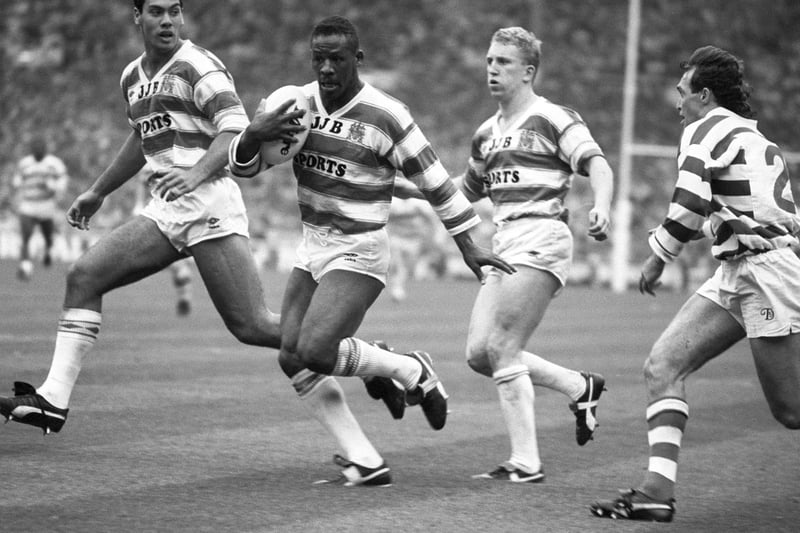 1988 of Wigan players Kevin Iro (left) and Shaun Edwards (second right) look on as team-mate Ellery Hanley is about to touch down in today's Silk Cut Challenge Cup final at Wembley, hotly pushed by Halifax's Martin Meredith (right).  Ellery Hanley became the first man to captain his side to three consecutive Challenge Cup victories on April 27, 1991.
