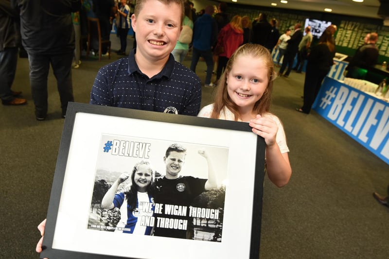 Young Latics fans Ethan Wimsey, 12, and sister Millie, ten, hold their photo as they feature in the campaign.