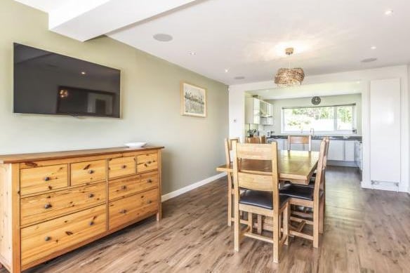 The room is open plan and leads through to the dining area. The current owners have made this a nice family space, with a large dining table and mounted tv unit, so everyone can relax together.