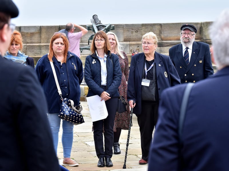Guests listen to the service on the pier.