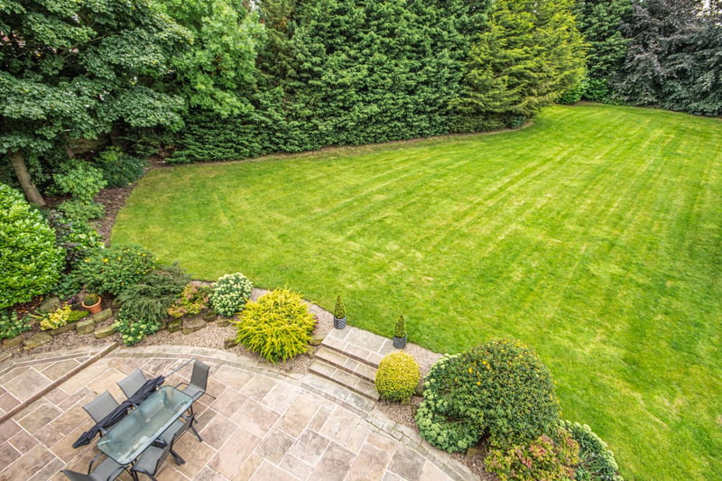 Trees, bushes and shrubs add privacy to the shaped lawn and patio area