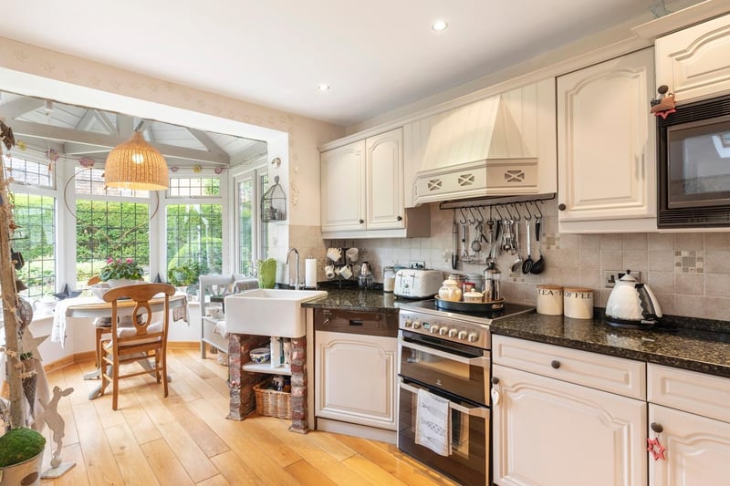 The kitchen is a light and airy space, with white cabinets and integrated appliances.
