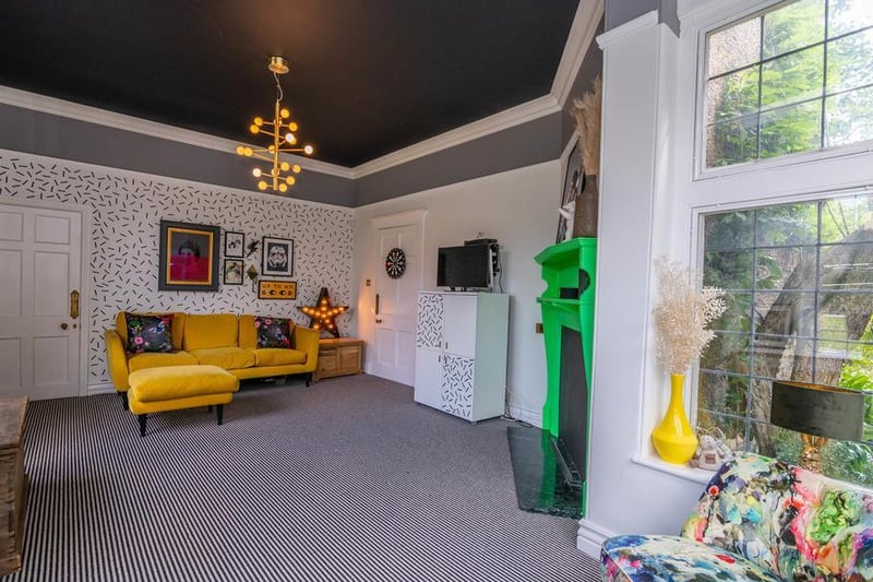 Also accessed from the hall is the another reception room currently used as a playroom. This wonderful bright and eclectic space has striking features like the neon green fireplace and dashed feature walls, but also plenty of space for children to have fun.