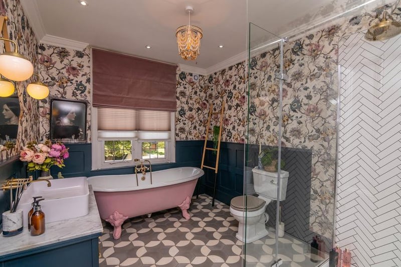 The master en-suite is opulent and luxurious with a feature pastel pink standalone bath. It also has a double sink and a white tiled walk in shower.