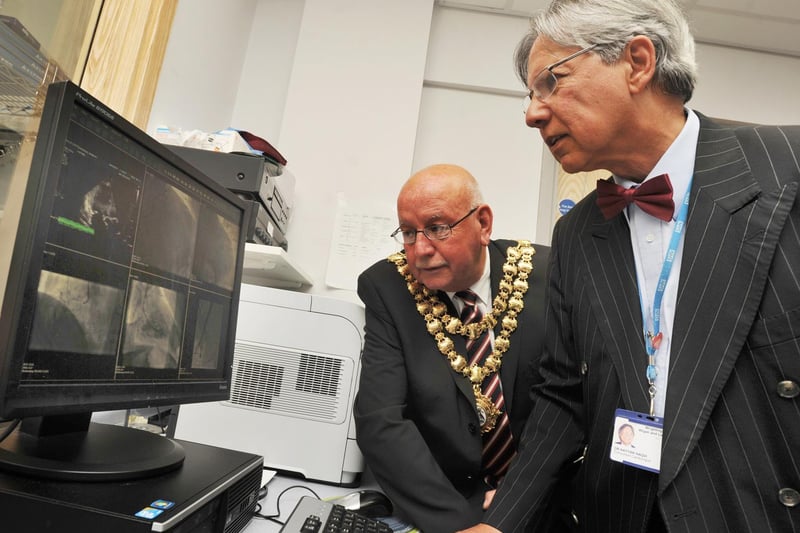 Consultant cardiology Dr Nayyar Naqvi OBE, right, shows vital equipment to the Mayor of Wigan councillor Billy Rotherham, left, during a visit to the Cardiology department at Wigan hospital, as he presents a £10,000 cheque to his chosen charity Heartbeat Two appeal, June 2013.
