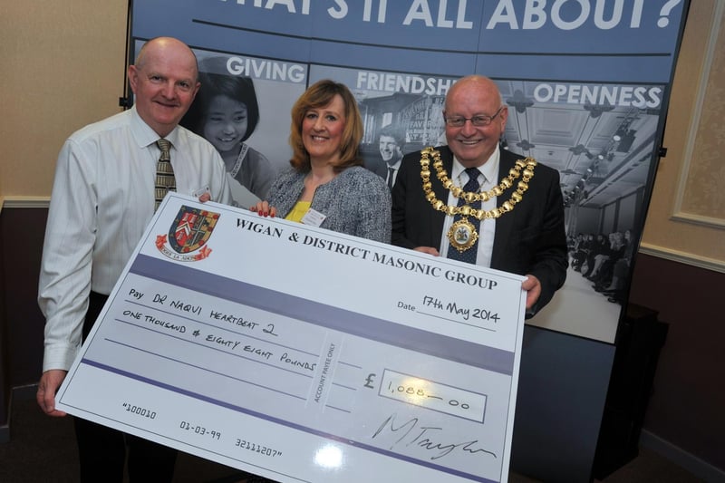 from left, Ashton Masonic group secretary Stewart Blagg presents a cheque to fundraising manager Elizabeth Titley and Mayor of Wigan councillor Billy Rotherham, representatives of the Heartbeat 2 Appeal, at the Giving Day, a celebration event to present funds to representatives of charities at Ashton Masonic Hall, Bryn.