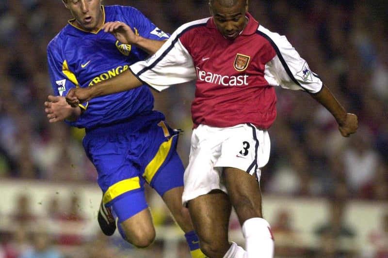 Arsenal's Ashley Cole crosses under pressure from Lee Bowyer.