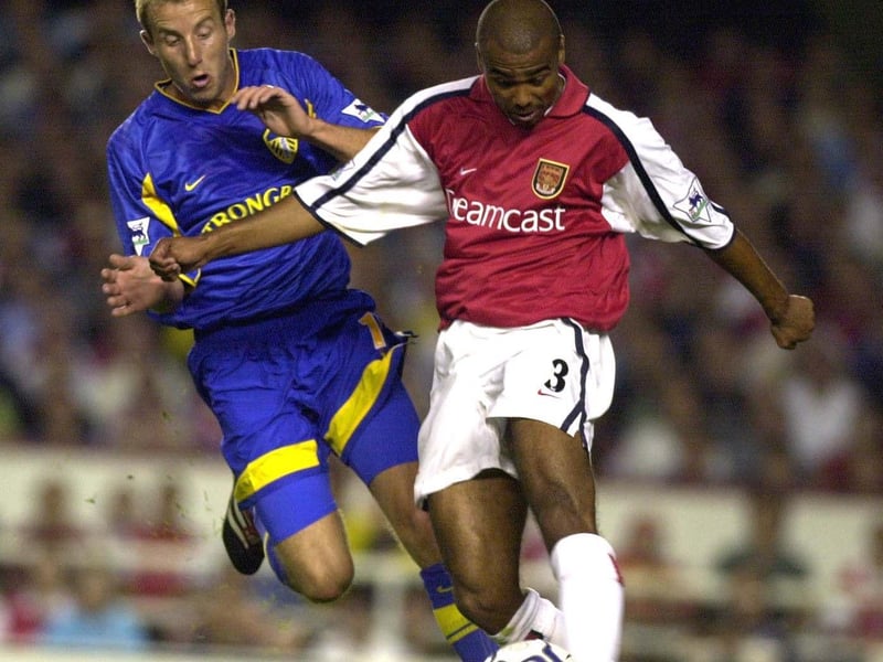 Arsenal's Ashley Cole crosses under pressure from Lee Bowyer.