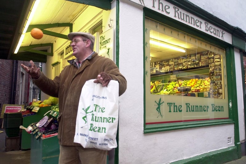 Greengrocer John Mills of The Runner Bean in Otley, who has customers' holiday pictures with his shopping bags in the photos.