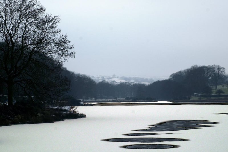 A sprinkle of January snow settles on the frozen ice at Lindley Wood Reservoir near Otley.
