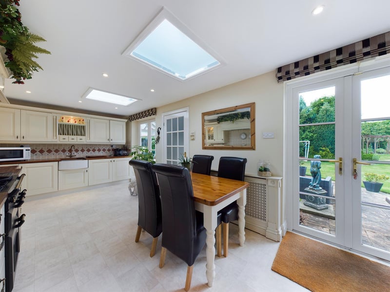 A patio and lawned garden can be seen through the kitchen doors and windows.