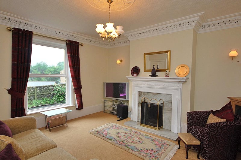 A stunning fireplace and large window within the sitting room.