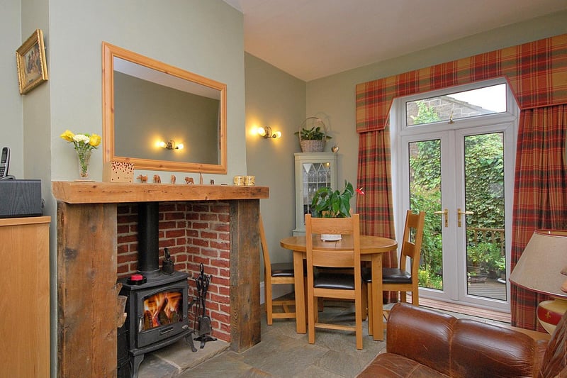 A rustic style fireplace with multi-fuel burner adds the cosy factor to this room with patio doors.