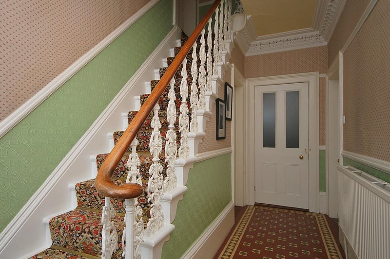 A feature staircase leads up from the house hallway