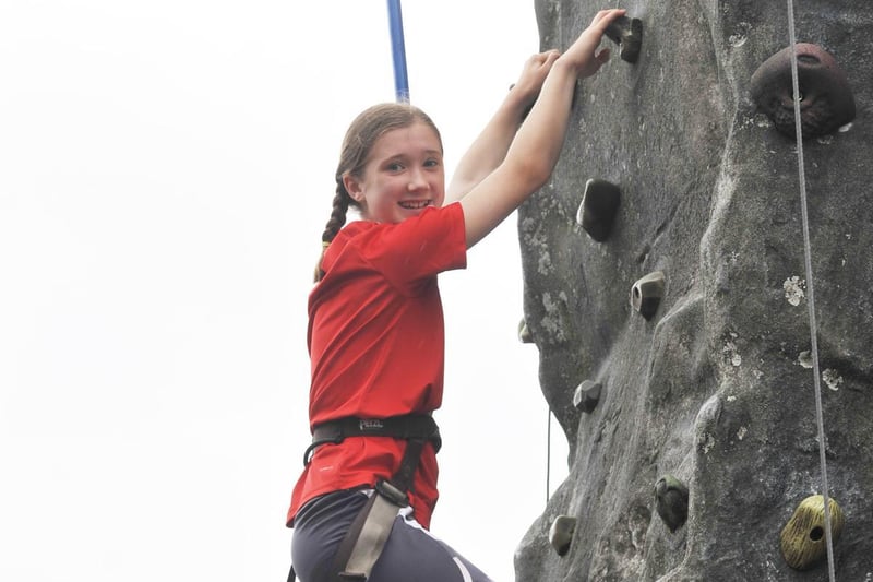 Abbie White, 11, scales the climbing wall.