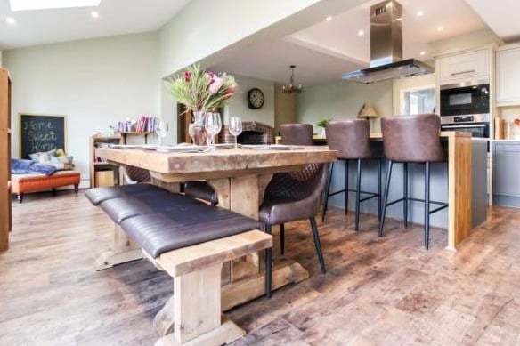 The dining area feels like a natural continuation of the living area. The current owners have added a rustic wooden table with benches to soften the sleek modern-style of the kitchen.
