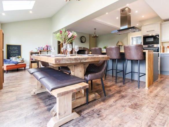 The dining area feels like a natural continuation of the living area. The current owners have added a rustic wooden table with benches to soften the sleek modern-style of the kitchen.