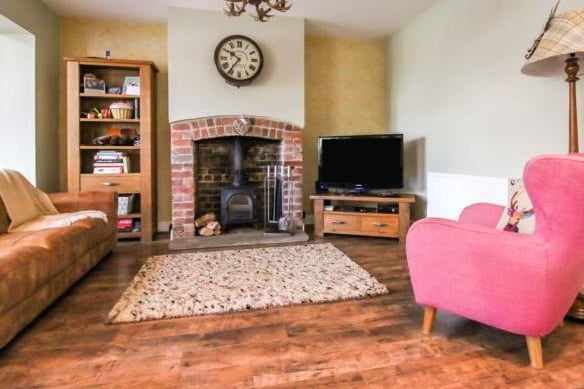 The living space is perfect for family life. Centred around the log burning fire, there's plenty of space for sitting and relaxing. The current owners have added a pop of colour with an eye-catching pink chair.