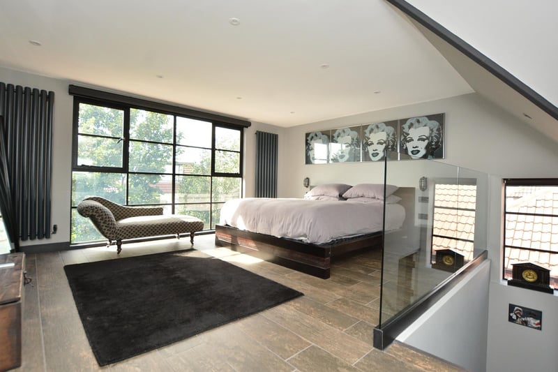 A staircase leads up to the second floor, where the former loft space has been converted to create an impressive master bedroom suite.