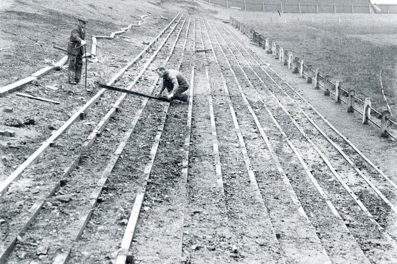 Trainer Maurice Wellock (right) measures out the new terracing at the Hunger Hill end of the ground, circa 1936.