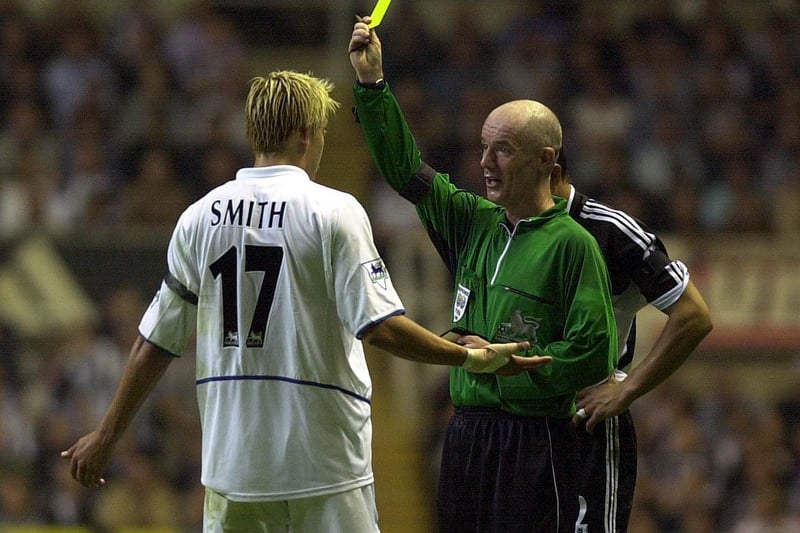 Striker Alan Smith receives a yellow card from referee Dermot Gallagher.