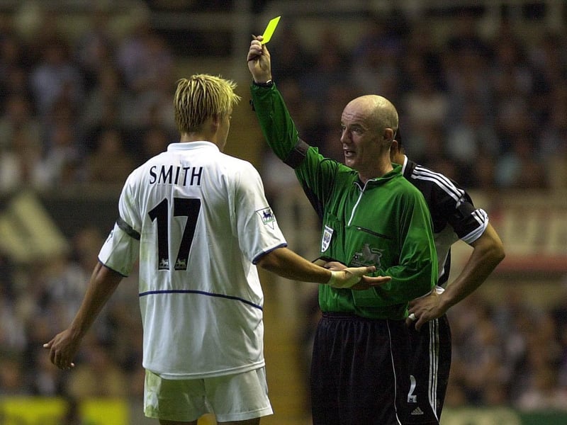 Striker Alan Smith receives a yellow card from referee Dermot Gallagher.