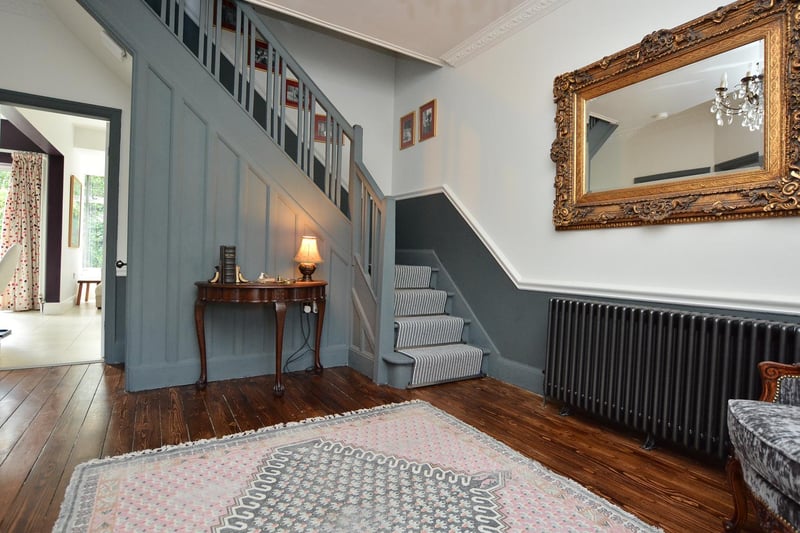Enter into the generous reception hallway. The stripped, stained wood flooring and gold and velvet furnishings add depth and warmth to the room. The turned stair case is painted a soft grey and complete with an under-stairs storage cupboard.