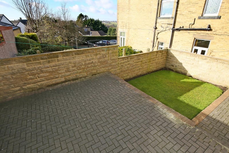 The back garden is split into two levels, patio area leading down to a lawn area.  It has a stone built wall perimeter.