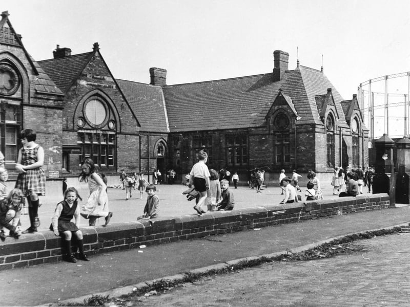 Children in the playground at Sheepscar School, Leeds, in June 1968, with a gasometer in the background