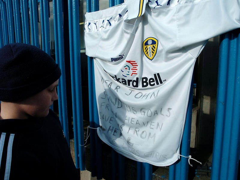 A young fan reads a message left on a Leeds United shirt in memory of former player John Charles.