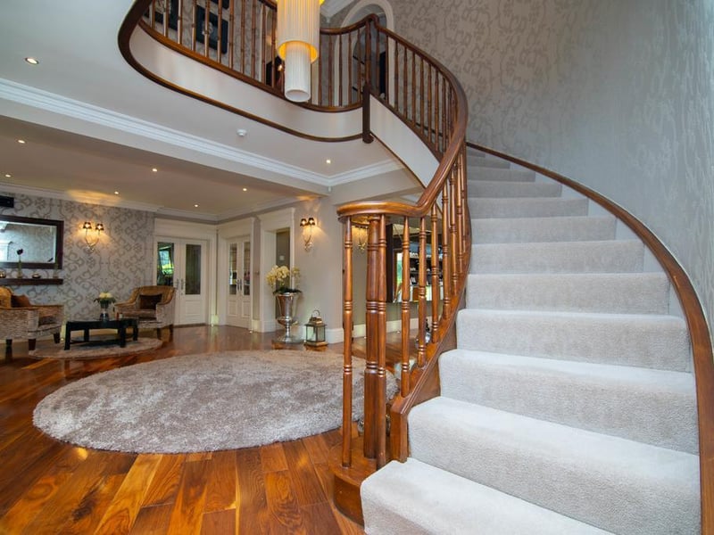 Enter into the outstanding reception hallway with a vanished hardwood flooring and a sweeping, bespoke staircase.