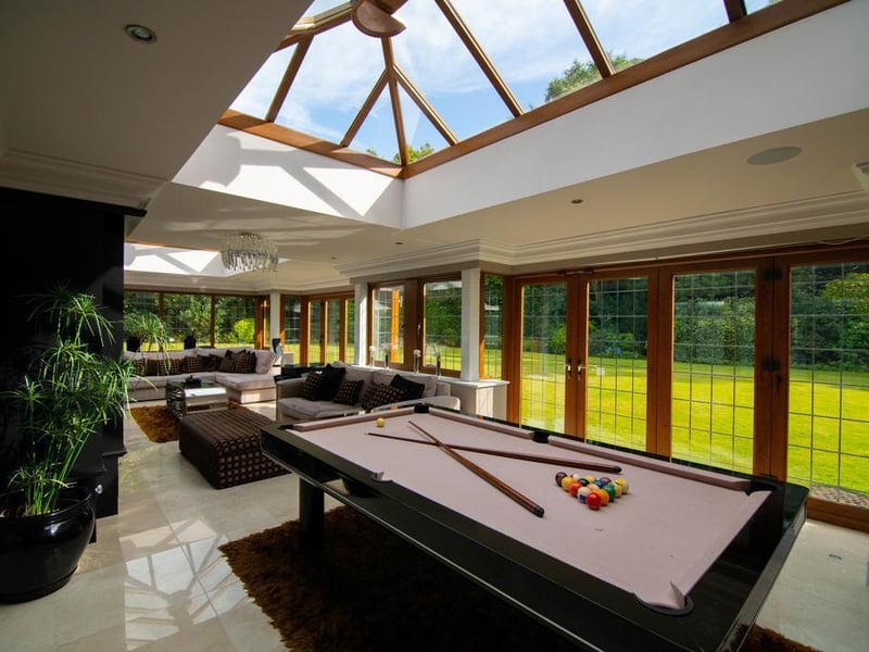 From the open plan kitchen/diner/living space is access to the orangery, which is currently used as a games room. This space benefits from feature glazing which provides views in to the leisure suite.