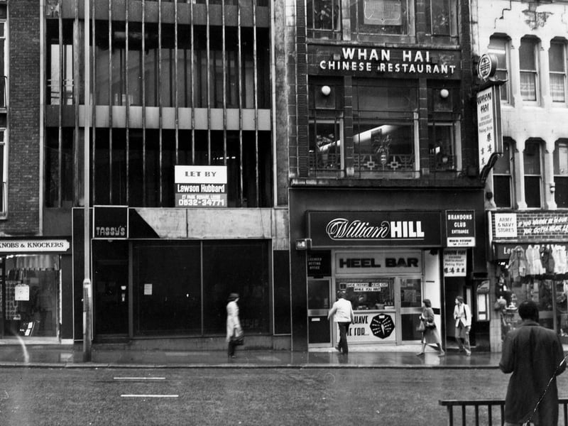 New Briggate in December 1979. On the left is Knobs and Knockers & Heel Bar shoe repairs, with the entrances to William Hill bookmakers and Brandons Club, and Whan Hai Chinese restaurant above.