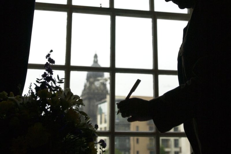 A member of the public signs the book of condolence at Leeds Civic Hall.