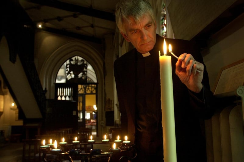 The Rev Canon Graham Smith lights a candle at Leeds Parish Church to remember the victims.