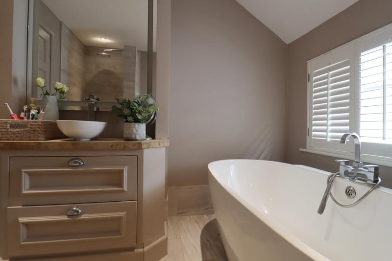 A large, deep bath takes pride of place in the pretty bathroom