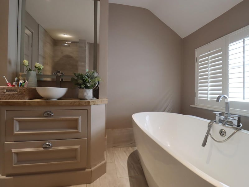 A large, deep bath takes pride of place in the pretty bathroom