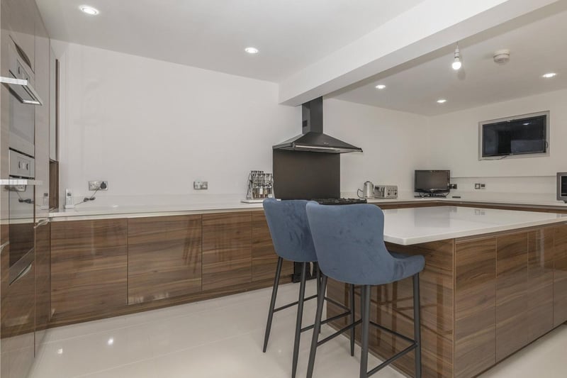 The kitchen features a free standing work island with a breakfast bar.
