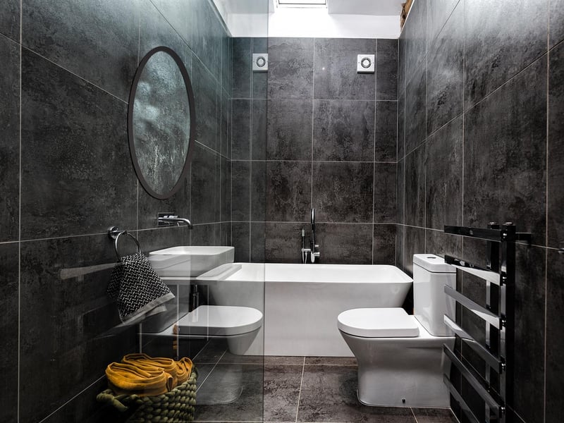 A fully tiled, modern bathroom facility.