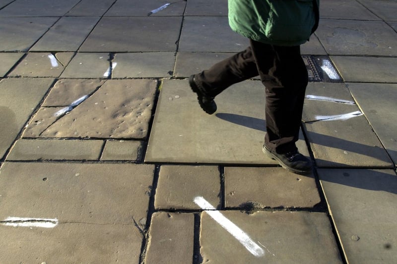 Damaged paving stones on Victoria Gardens. The white markers indicate damaged stones.