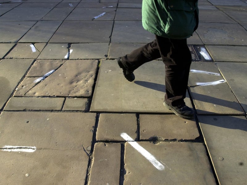 Damaged paving stones on Victoria Gardens. The white markers indicate damaged stones.