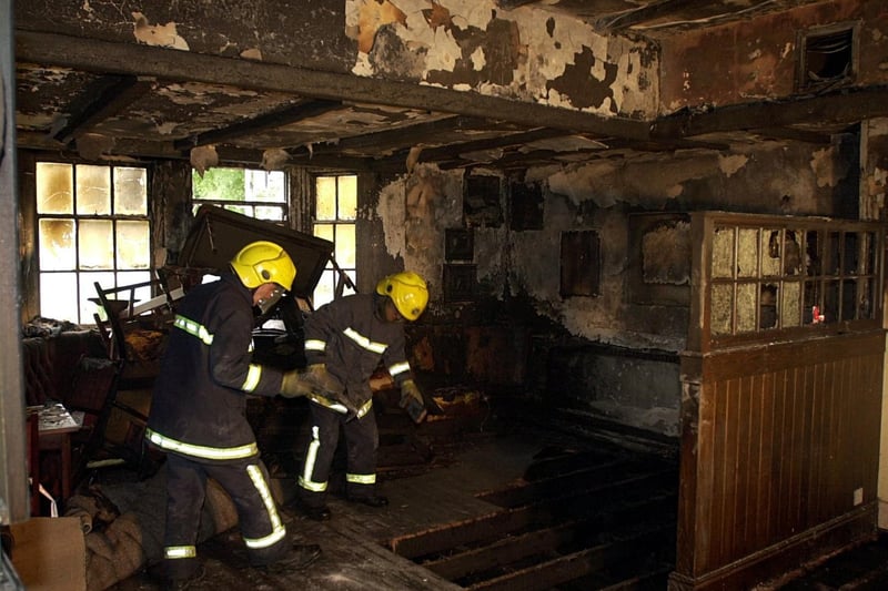 Fire fighters from Cookridge work in the fire damaged main bar area at the Dyneley Arms in October 2002.