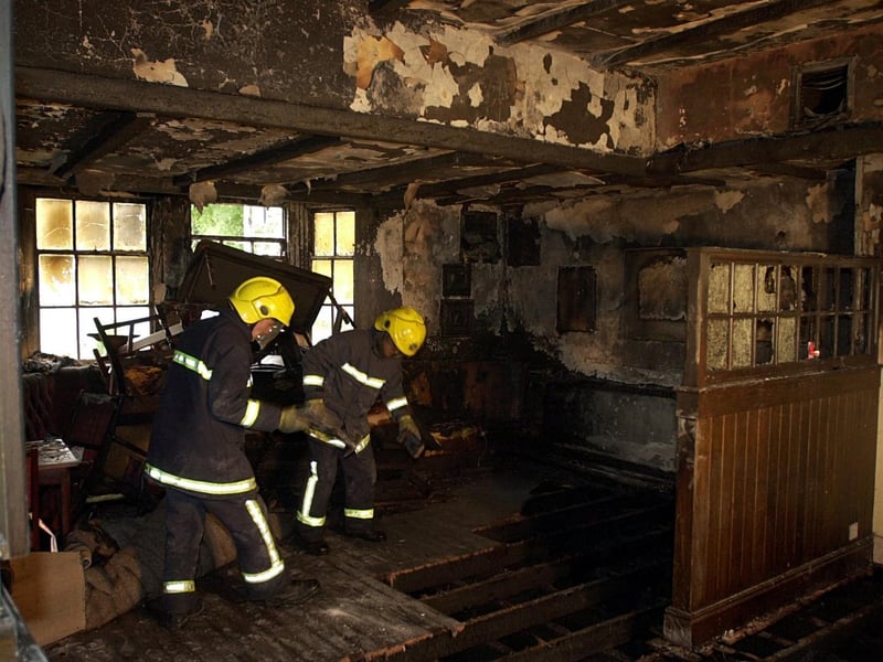 Fire fighters from Cookridge work in the fire damaged main bar area at the Dyneley Arms in October 2002.