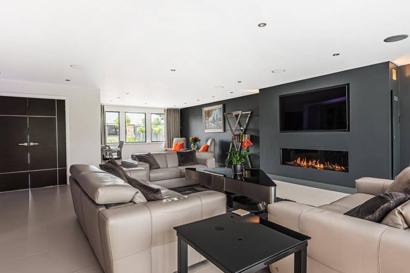 The modern room's focal point the the fabulous central feature fireplace with a wall mounted gas flame fire unit and custom built in TV unit above. It also has built-in surround sound speakers making it a great place to sit back and relax.