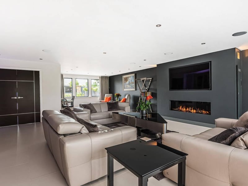 The modern room's focal point the the fabulous central feature fireplace with a wall mounted gas flame fire unit and custom built in TV unit above. It also has built-in surround sound speakers making it a great place to sit back and relax.