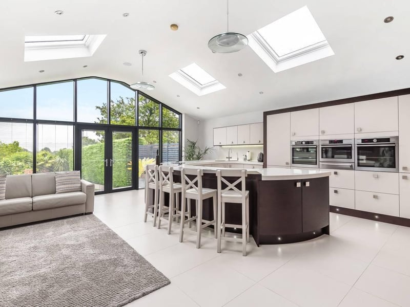 The modern open plan family kitchen is breath taking. An extensive range of contemporary, bespoke units are fitted at floor and wall height with ‘Corian’ top work surfaces moulded to form a curved central island unit incorporating an array of high spec. integrated appliances with a built-in breakfast bar unit.